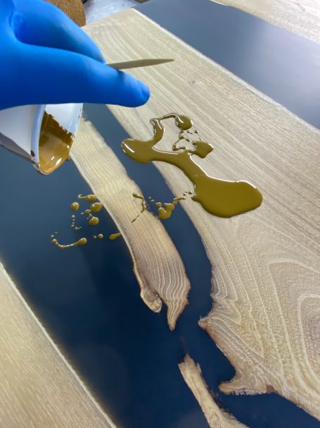 Application d'une huile de finition sur une table rivière